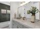 Modern bathroom featuring marble countertops and a bathtub with elegant green tile at 12638 E Cortez Dr, Scottsdale, AZ 85259