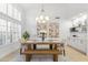 Dining room with shuttered windows, statement chandelier, seating with benches and marble-topped sideboard at 12638 E Cortez Dr, Scottsdale, AZ 85259