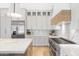 Bright kitchen featuring white cabinets, a marble backsplash, and stainless steel appliances at 12638 E Cortez Dr, Scottsdale, AZ 85259