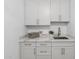 Laundry room featuring white cabinetry, marble counters, and gold hardware at 12638 E Cortez Dr, Scottsdale, AZ 85259
