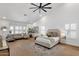 Spacious main bedroom featuring wood floors, a ceiling fan, a seating area and white walls at 12638 E Cortez Dr, Scottsdale, AZ 85259