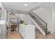 Bright kitchen and dining area with island seating and a staircase with iron banisters at 13237 N 25Th Dr, Phoenix, AZ 85029