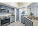 Well-lit kitchen featuring stainless steel appliances, gray cabinets, and a view into the dining area at 1331 W Baseline Rd # 360, Mesa, AZ 85202