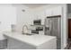 Bright kitchen features white cabinetry, stainless steel appliances, and a quartz countertop island with breakfast bar seating at 1351 N Pleasant Dr # 2011, Chandler, AZ 85225