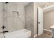 Bathroom with white tub, black hardware, and tiled shower at 13805 N 31St Ave, Phoenix, AZ 85053
