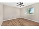 A cozy bedroom featuring wood-look flooring, fan and window at 13805 N 31St Ave, Phoenix, AZ 85053