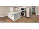 Bright kitchen featuring white cabinets, a stylish island, stainless steel appliances, and wood-look floors at 13805 N 31St Ave, Phoenix, AZ 85053