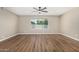 Spacious living room with wood-look flooring, ceiling fan, and a large window overlooking the greenery at 13805 N 31St Ave, Phoenix, AZ 85053