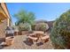 Backyard featuring a stone picnic table, desert landscaping, and a built-in BBQ grill at 14822 N Tonya Cir, El Mirage, AZ 85335