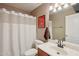 Well-lit bathroom featuring a shower-tub combo with neutral-toned decor and a framed dog art print at 14822 N Tonya Cir, El Mirage, AZ 85335