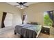 Large main bedroom with two windows, ceiling fan, and ensuite bathroom access creating a relaxing retreat at 14822 N Tonya Cir, El Mirage, AZ 85335