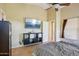 Comfortable main bedroom featuring a TV, storage shelves, and seamless transition to the ensuite bathroom at 14822 N Tonya Cir, El Mirage, AZ 85335
