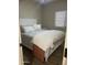 Bright bedroom with a white frame bed with a white and gray comforter, and a window with blinds at 178 W Pacific Dr, Casa Grande, AZ 85122