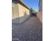Side exterior of the home with gravel, stucco siding, and windows providing a practical outdoor view at 178 W Pacific Dr, Casa Grande, AZ 85122