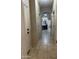 A hallway with tile flooring, access to bedrooms, and views into other areas of the house at 178 W Pacific Dr, Casa Grande, AZ 85122