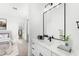 Bright bathroom features a stylish vanity, modern fixtures, and a black-framed mirror with serene bedroom view at 1785 W Brooke Ln, Queen Creek, AZ 85144