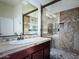 Modern bathroom with a walk-in shower with tile surround and glass door, and a vanity at 1809 E Gwen St, Phoenix, AZ 85042