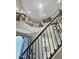 A bright foyer with stairs, an elegant wrought iron banister, and a dazzling chandelier at 1809 E Gwen St, Phoenix, AZ 85042
