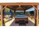 Enjoy a relaxing soak in the backyard hot tub under a shaded gazebo with a TV and lush greenery at 1809 E Gwen St, Phoenix, AZ 85042