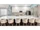 A view of the kitchen showcases a large quartz island with seating for six, alongside modern appliances and white cabinetry at 1809 E Gwen St, Phoenix, AZ 85042