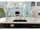 Kitchen sink with dark cabinets, white countertop, and view into the living room fireplace and blue walls at 1809 E Gwen St, Phoenix, AZ 85042