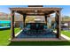 Entertain in style with this backyard outdoor kitchen under a gazebo, featuring a built-in grill and dining area at 1809 E Gwen St, Phoenix, AZ 85042