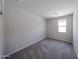 An empty bedroom with neutral carpeting and a window providing natural light at 18260 W Daley Ln, Surprise, AZ 85387