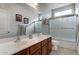 Bathroom with tiled shower and tub, wooden vanity with double sinks and large mirror at 18459 E Ranch Rd, Queen Creek, AZ 85142