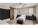 Bedroom features a barn door to the bathroom, modern ceiling fan, and multiple seating options at 18459 E Ranch Rd, Queen Creek, AZ 85142