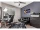 Bedroom features a modern ceiling fan, black futon, and a window for natural lighting at 18459 E Ranch Rd, Queen Creek, AZ 85142