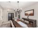Elegant dining room with a long wooden table, chandelier, and artwork, perfect for gatherings at 18459 E Ranch Rd, Queen Creek, AZ 85142