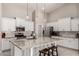 Well-lit kitchen with a large island, white cabinets, pendant lighting, and stainless steel appliances at 18459 E Ranch Rd, Queen Creek, AZ 85142