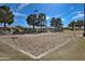 A well-maintained sand volleyball court surrounded by green grass and trees at 18459 E Ranch Rd, Queen Creek, AZ 85142