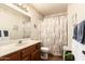Bathroom with floral accents, single sink vanity, and shower-tub combo with decorative shower curtain at 2105 S Zinnia Ave # 468, Mesa, AZ 85209