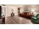 Cozy living room with wood-look flooring, leather sofa, and display shelving at 2105 S Zinnia Ave # 468, Mesa, AZ 85209