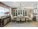 Inviting dining room with a long wood table, seating for eight, brick wall accent, and soft, natural light at 2111 W Mulberry Dr, Phoenix, AZ 85015