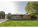 Charming single-story brick home with a well-manicured lawn, mature trees, and a covered patio at 2111 W Mulberry Dr, Phoenix, AZ 85015