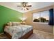 Bedroom features a ceiling fan and a bright window with beige carpet at 21665 N 47Th Pl, Phoenix, AZ 85050