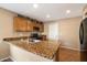 Updated kitchen featuring granite countertops, wood cabinets, tile flooring, and stainless steel sink and faucet at 21665 N 47Th Pl, Phoenix, AZ 85050