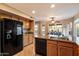 Bright kitchen features granite counters, wood cabinets, and a black refrigerator, with a view of the pool at 21665 N 47Th Pl, Phoenix, AZ 85050
