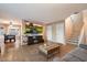 Open-concept living room with dining area, featuring tile flooring, a TV and staircase at 21665 N 47Th Pl, Phoenix, AZ 85050