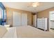 Bright main bedroom with carpeted floors, a ceiling fan, sliding closet doors, and an ensuite bathroom at 21665 N 47Th Pl, Phoenix, AZ 85050