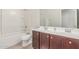 Well-lit bathroom featuring a shower over tub and double sink vanity at 25945 W Runion Dr, Buckeye, AZ 85396