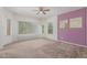 Bedroom featuring carpet, neutral walls, a purple accent wall, and lots of natural light at 25945 W Runion Dr, Buckeye, AZ 85396