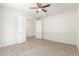 Bedroom with neutral walls, tile floors, ceiling fan, and an open doorway to another room at 25945 W Runion Dr, Buckeye, AZ 85396