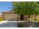 Charming single-Gathering home with a two-car garage, a well-manicured lawn, and a beautiful shade tree in the front yard at 25945 W Runion Dr, Buckeye, AZ 85396