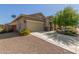View of a home with a two-car garage, desert landscaping, and a satellite dish, set against a clear blue sky at 25945 W Runion Dr, Buckeye, AZ 85396