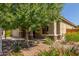 Charming home exterior with stone accents, a well-manicured lawn, and a variety of colorful flowers enhancing its curb appeal at 25945 W Runion Dr, Buckeye, AZ 85396