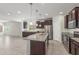 Well-equipped kitchen with stainless steel appliances, granite countertops, a center island, and dark wood cabinetry at 25945 W Runion Dr, Buckeye, AZ 85396