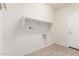 Bright laundry room featuring tile floors, shelving, and utility connections at 25945 W Runion Dr, Buckeye, AZ 85396